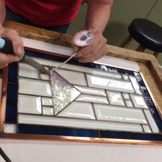 Student soldering stained glass project