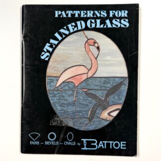 Black book cover titled 'Patterns for Stained Glass' with a round stained-glass scene of a pink flamingo over blue water, on a dark background.