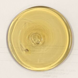 Gold-colored circular disk with a raised center and inner circle, possibly a seal or button-like object viewed from above.