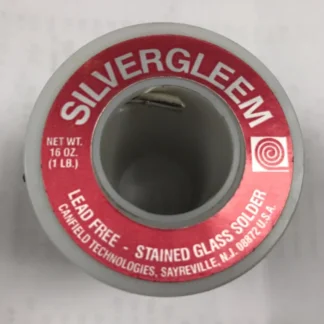 Close-up of a spool of lead-free stained glass solder with a red label reading SILVERGLEEM.