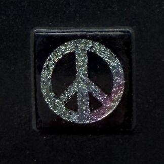 Glittery silver peace symbol on a black square background.
