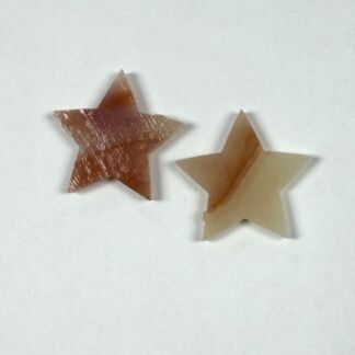 Two paper stars, one brown and one beige, placed on a white surface.