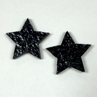Two black glittery five-point stars on a white surface.