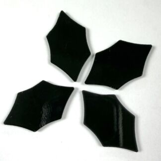Four irregular black glass shards arranged in a loose circle on a white background.