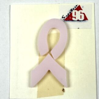 Pink ribbon cutout attached to a pale card, symbolizing breast cancer awareness.