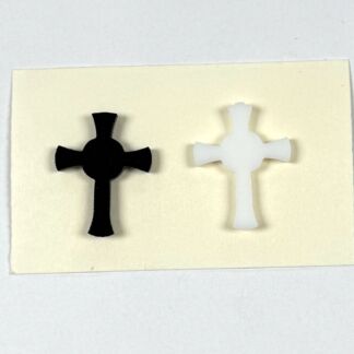 Two cross-shaped cutouts, one black and one white, displayed on a pale card.