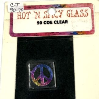 Label reads HOT N SHINY GLASS, 90 COE CLEAR, above a small square with a colorful peace-sign tile on black velvet.