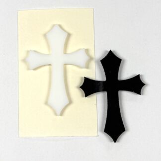 White decorative cross cutout on a cream card, placed beside a black cross cutout